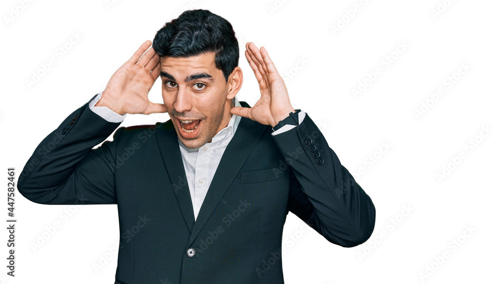 Handsome hispanic man wearing business clothes smiling cheerful playing peek a boo with hands showing face. surprised and exited Handsome hispanic man wearing business clothes smiling cheerful playing peek a boo with hands showing face. surprised and exited