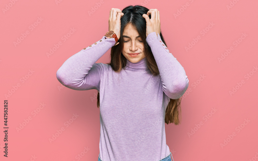 Young beautiful teen girl wearing turtleneck sweater suffering from headache desperate and stressed because pain and migraine. hands on head. Young beautiful teen girl wearing turtleneck sweater suffering from headache desperate and stressed because pain and migraine. hands on head.