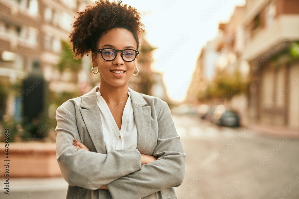 Obraz premium Young african american businesswoman with arms crossed standing at the city.