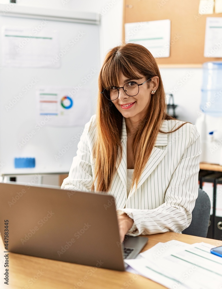 Young hispanic businesswoman smiling happy working at the office.