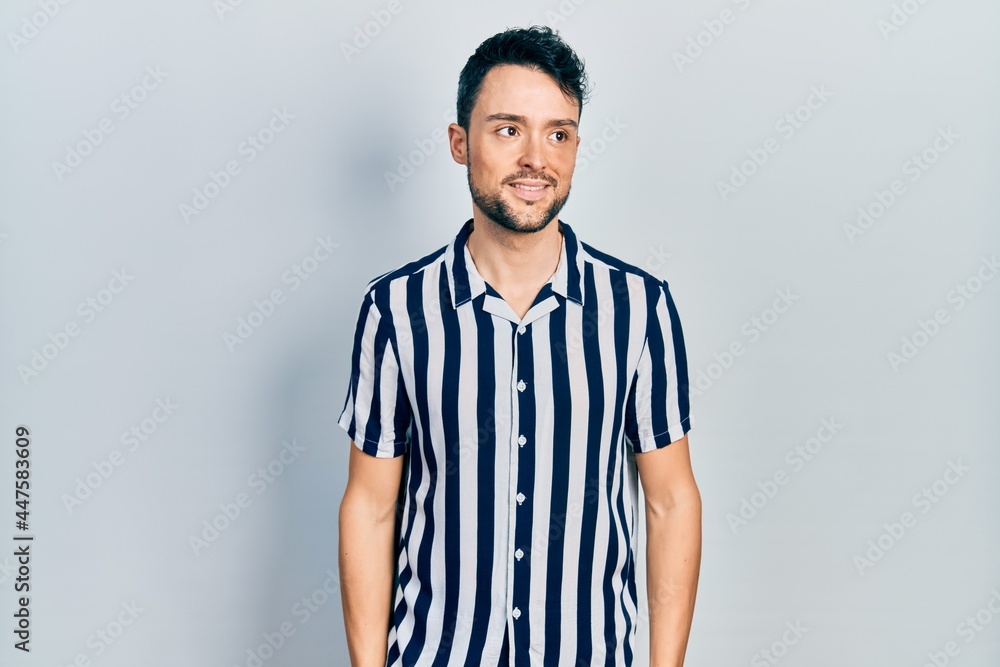 custom made wallpaper toronto digitalYoung hispanic man wearing casual clothes looking away to side with smile on face, natural expression. laughing confident.