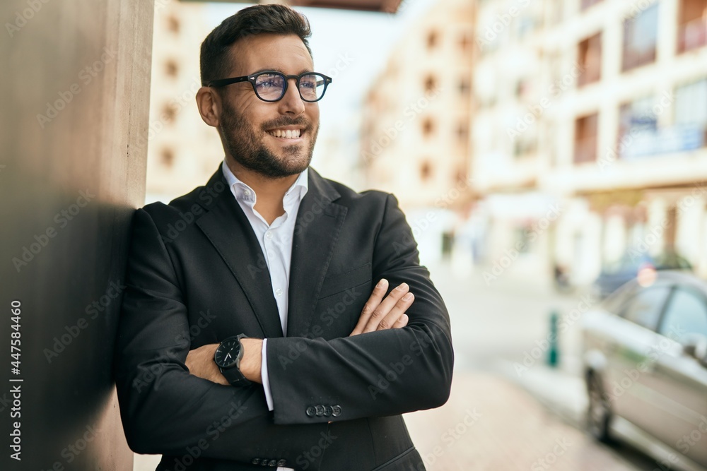 Young hispanic businessman with arms crossed smiling happy at the city. Young hispanic businessman with arms crossed smiling happy at the city.