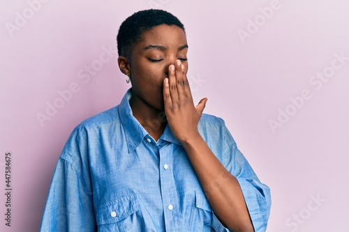 Young african american woman wearing casual clothes bored yawning tired covering mouth with hand. restless and sleepiness.