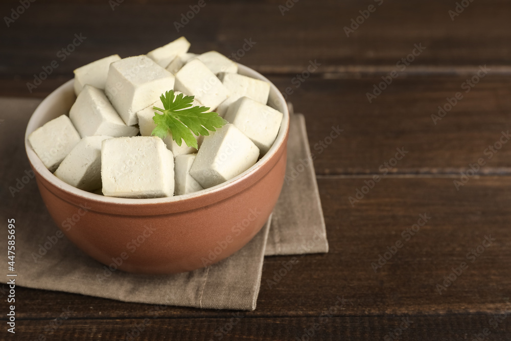 Delicious tofu with parsley on wooden table. Space for text Delicious tofu with parsley on wooden table. Space for text