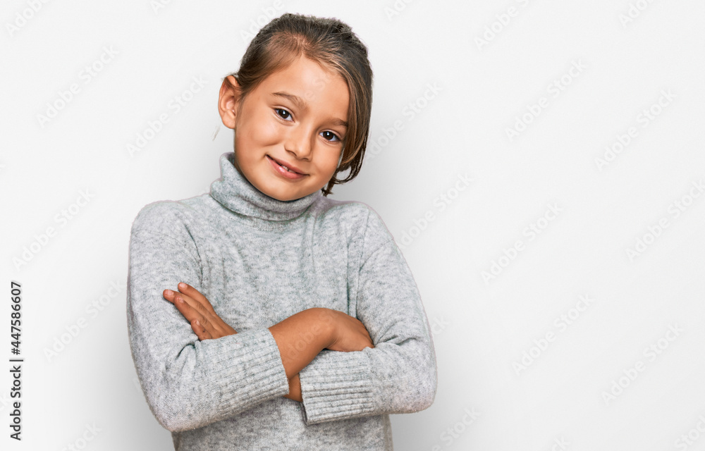 Little beautiful girl wearing casual turtleneck sweater happy face smiling with crossed arms looking at the camera. positive person.