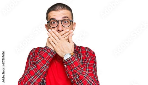 Hispanic young man wearing casual clothes shocked covering mouth with hands for mistake. secret concept.