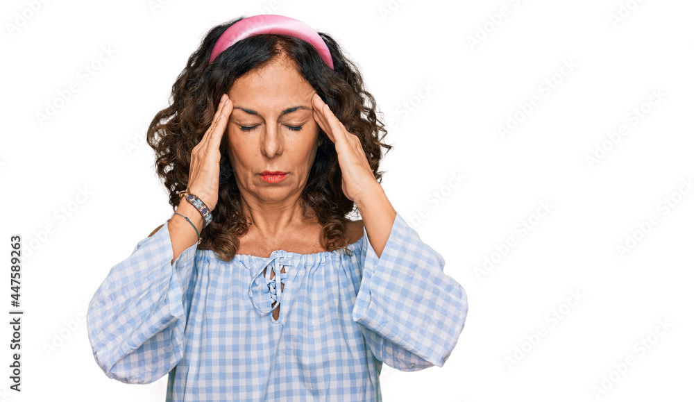 Middle age hispanic woman wearing casual clothes suffering from headache desperate and stressed because pain and migraine. hands on head. Middle age hispanic woman wearing casual clothes suffering from headache desperate and stressed because pain and migraine. hands on head.