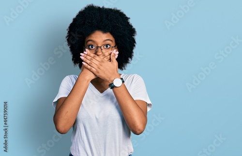 Young african american woman wearing casual white t shirt shocked covering mouth with hands for mistake. secret concept.