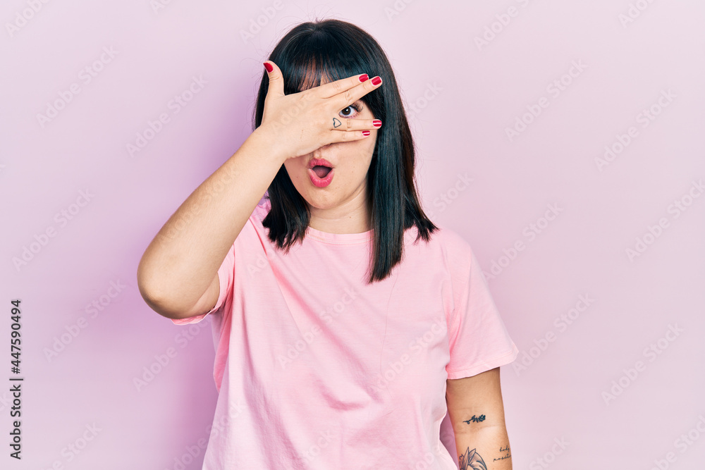 Young hispanic woman wearing casual clothes peeking in shock covering face and eyes with hand, looking through fingers with embarrassed expression. Young hispanic woman wearing casual clothes peeking in shock covering face and eyes with hand, looking through fingers with embarrassed expression.