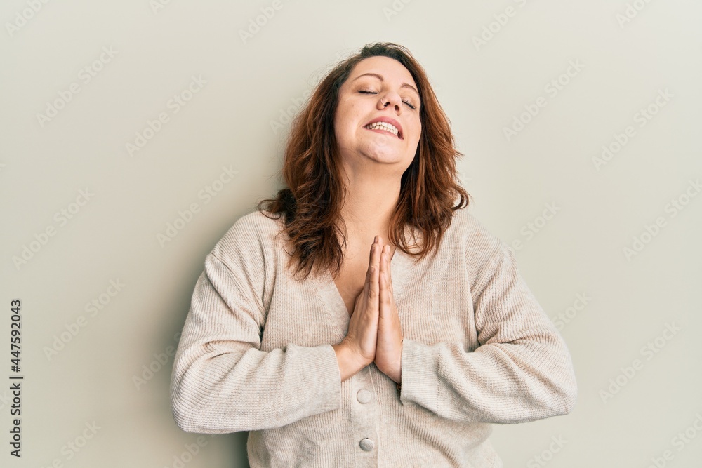 Young caucasian woman wearing casual clothes begging and praying with hands together with hope expression on face very emotional and worried. begging. Young caucasian woman wearing casual clothes begging and praying with hands together with hope expression on face very emotional and worried. begging.