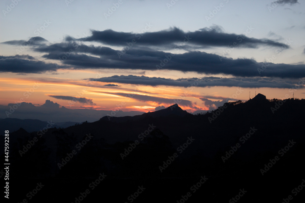 Beautiful orange and blue sunset with a huge mountain rage silhouette 