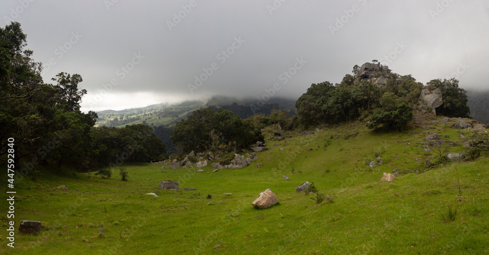 Fototapeta premium Colombian andean mountain countryside landscape with a monolith hills, big stones and a green valey in cloudy day