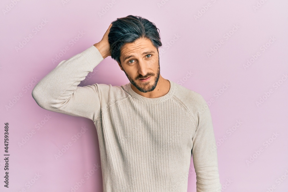 Young hispanic man wearing casual winter sweater confuse and wonder about question. uncertain with doubt, thinking with hand on head. pensive concept. Young hispanic man wearing casual winter sweater confuse and wonder about question. uncertain with doubt, thinking with hand on head. pensive concept.