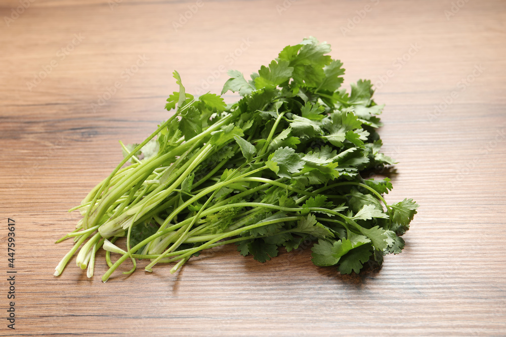 Bunch of fresh aromatic cilantro on wooden table Bunch of fresh aromatic cilantro on wooden table