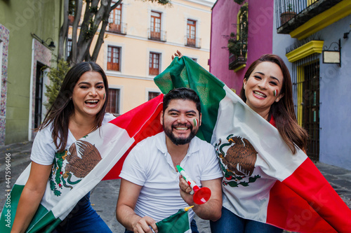 Smiling mexican people on Cinco de Mayo holding flags and trumpets in Mexico photo