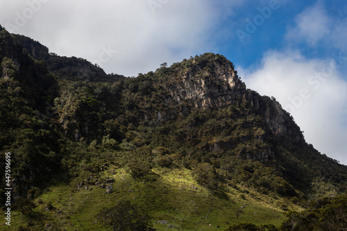 A high colombian andean rocky peak details with cloudy sky and green grassland
