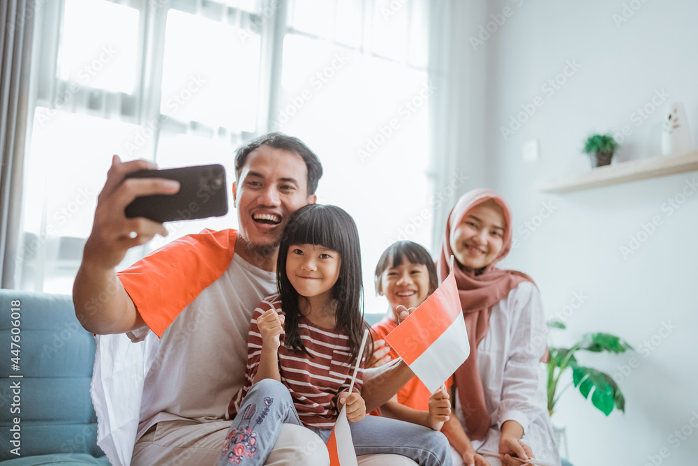 indonesian muslim asian family making selfie and video call using their phone at home indonesian muslim asian family making selfie and video call using their phone at home