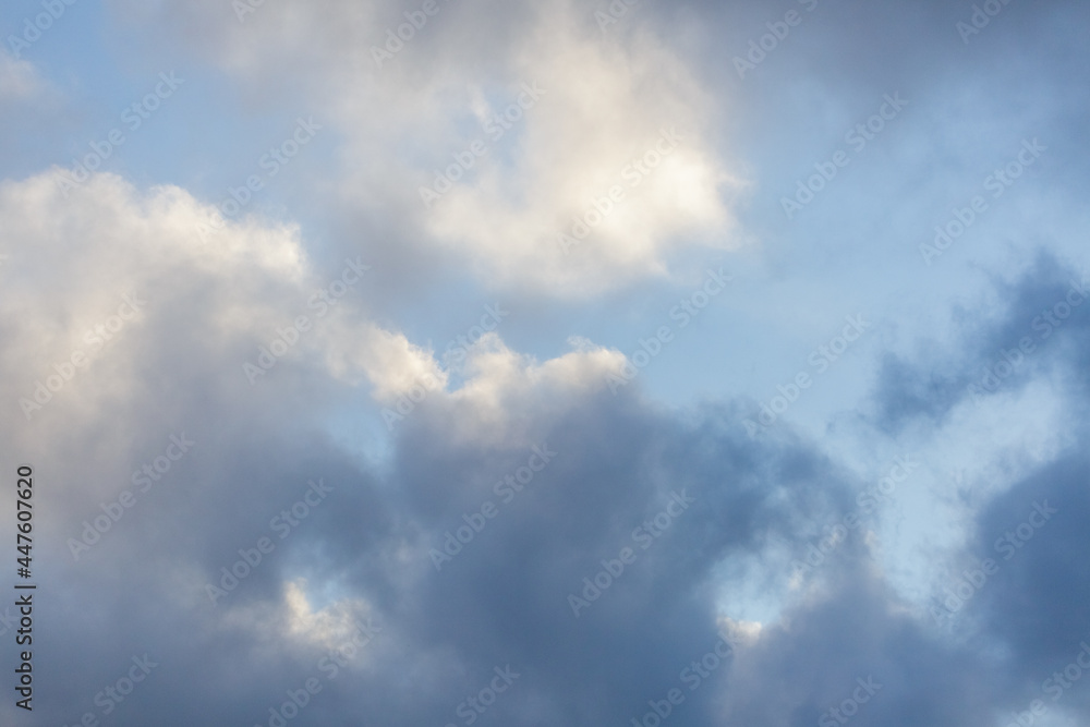 Simple beautiful gloomy blue sky with fluffy clouds on peaceful summer morning day as a background. Gray and white color blurred horizon texture photography