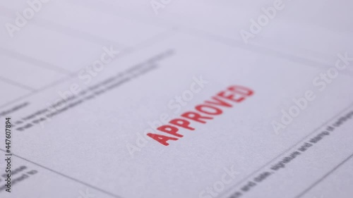 Business financial document with stamping message with rubber stamp. Closeup document marked with approved stamp