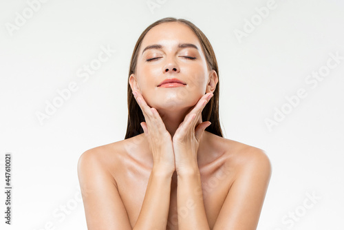 Beautiful Caucasian woman with clean glowing face skin in isolated studio white background for beauty and skin care concepts
