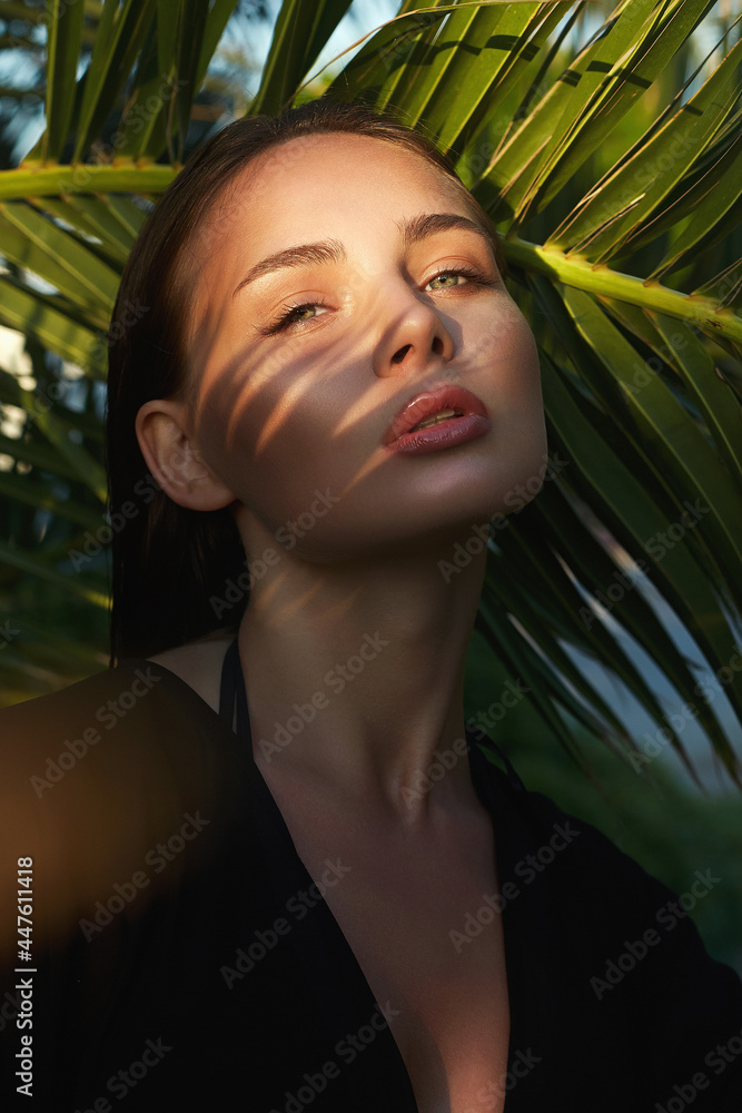 beautiful passion girl in palm leaves. young woman with Make-up under palm tree beautiful passion girl in palm leaves. young woman with Make-up under palm tree