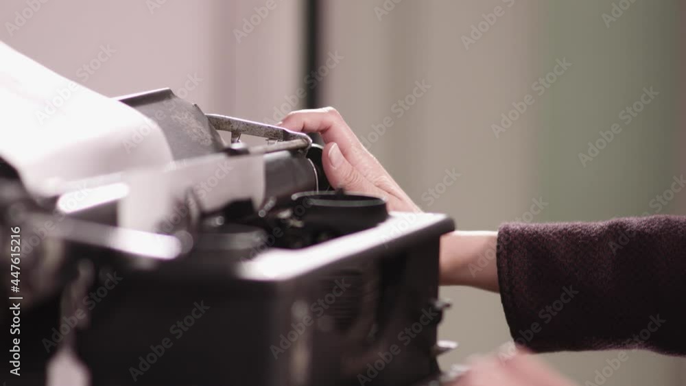 slow motion close up shot of a woman fixing paper roll on old vintage typewriter, from the side, handheld. writer, news, retro media concept slow motion close up shot of a woman fixing paper roll on old vintage typewriter, from the side, handheld. writer, news, retro media concept