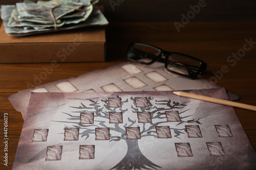 Photo Papers with family tree templates, pencil, photos and glasses on wooden table, c