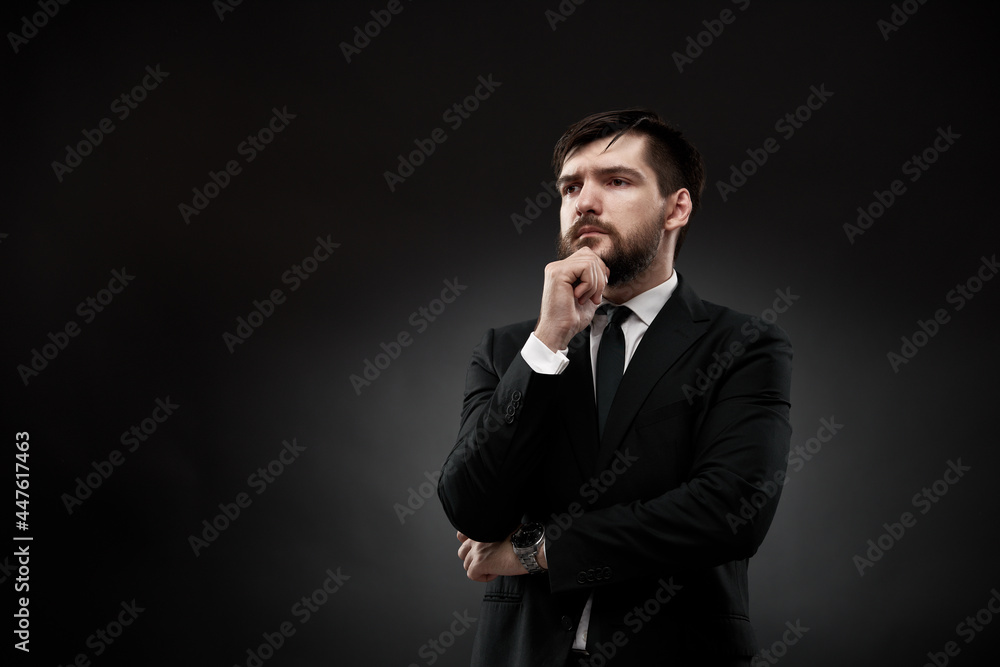 Serious businessman holding hand near face Serious businessman holding hand near face