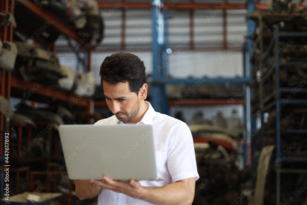 Businessman using laptop computer working or checking stock in warehouse factory, entrepreneurship or business owner concept Businessman using laptop computer working or checking stock in warehouse factory, entrepreneurship or business owner concept