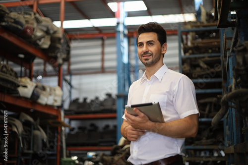 Businessman using laptop computer working or checking stock in warehouse factory, entrepreneurship or business owner concept