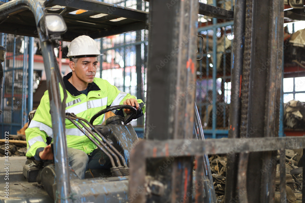 Worker or Engineer or driver drive forklift in machine spare part engine warehouse, freight and handling in factory Worker or Engineer or driver drive forklift in machine spare part engine warehouse, freight and handling in factory