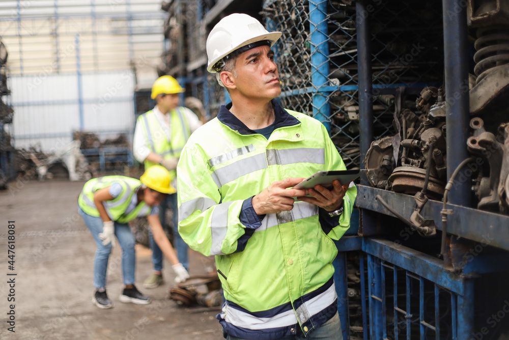 Worker or Engineer work in factory and using tablet for checking stock and inspection in machine spare part engine warehouse Worker or Engineer work in factory and using tablet for checking stock and inspection in machine spare part engine warehouse