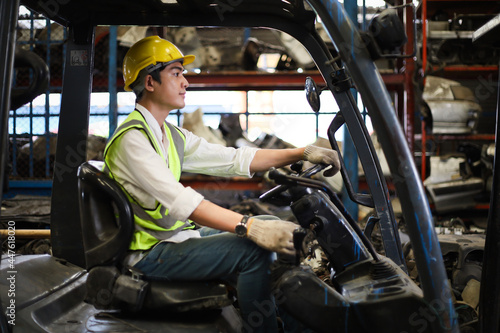Worker or Engineer or driver drive forklift in machine spare part engine warehouse, freight and handling in factory