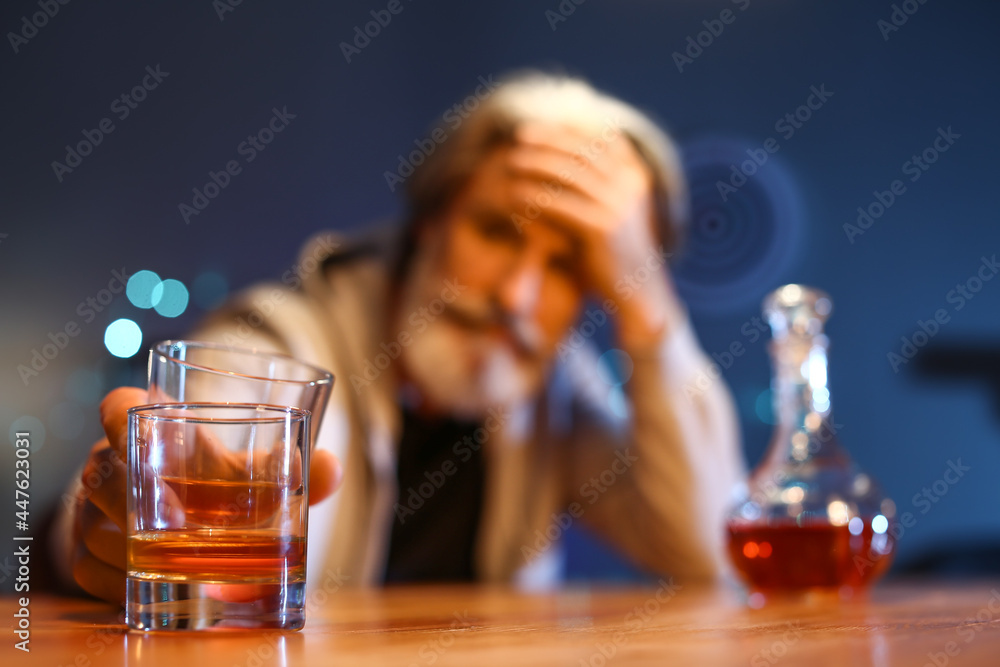 Senior man with glass of drink late in evening at home, closeup Senior man with glass of drink late in evening at home, closeup
