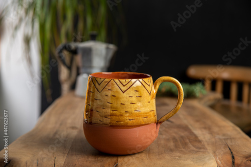 cup of coffee with mocha pot on a wooden table
