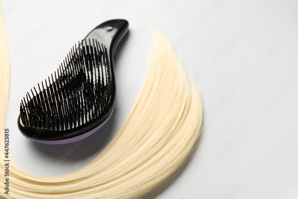 Plastic hair brush with strand on grey background Plastic hair brush with strand on grey background