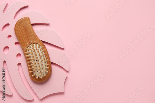 Wooden hair brush on color background