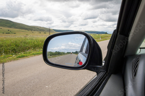 Car mirror and highway view, black car and nature landscape