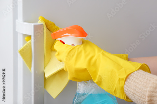 Woman cleaning fridge in room, closeup