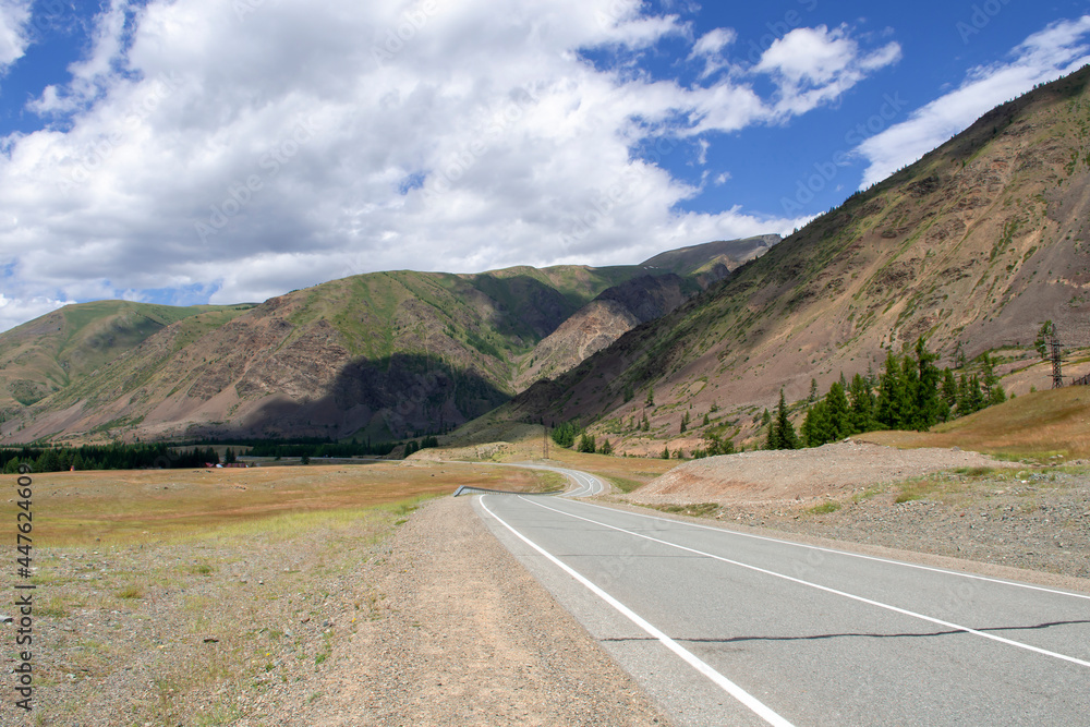 Fototapeta premium mountains against the background of clouds and the road stretching into the distance