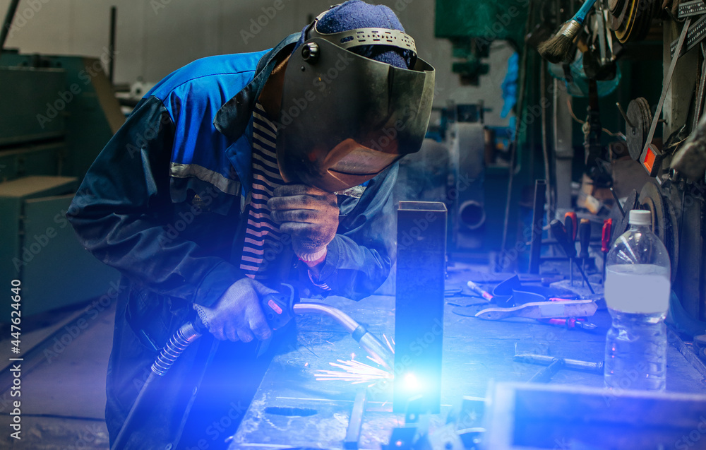 Fototapeta Welder working with electrode at semi-automatic arc welding.