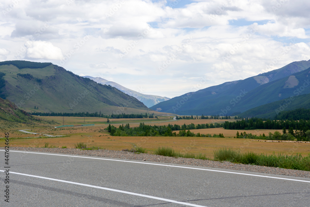 Fototapeta premium mountains against the background of clouds and the road stretching into the distance