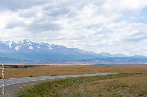 snowy peaks of mountains and steppe on a background of cloudy sky © Вячеслав 