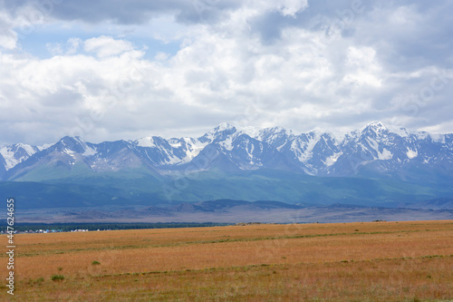 snowy peaks of mountains and steppe on a background of cloudy sky
