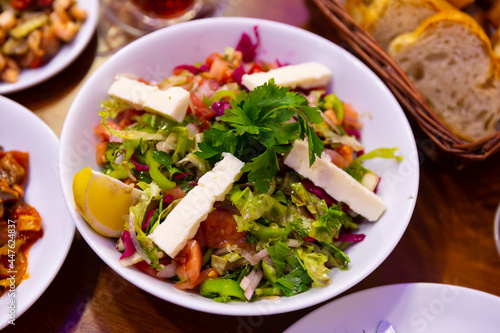 Healthy organic turkish choban salad with cheese, tomato, cucumber, herbs and lemon