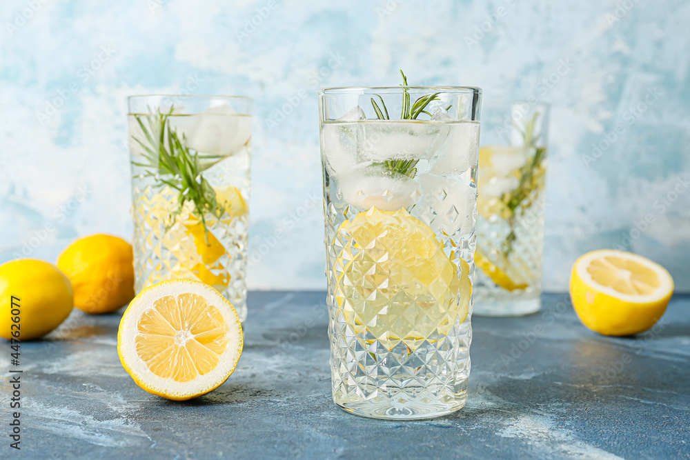 Fototapeta premium Glasses of tasty lemonade with rosemary on color background