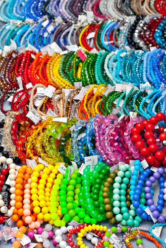 Necklace of colorful stones on the table. Many different jewelry and beads made of natural precious minerals. Beaded jewelry is on sale at the fair. © Ivan