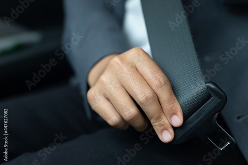 Formally dressed woman wearing a seat belt for safety while driving