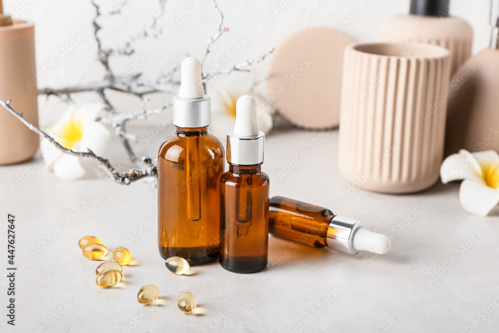Cosmetic dropper bottles and pills on light background, closeup Cosmetic dropper bottles and pills on light background, closeup