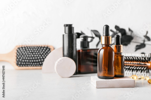 Bottles of cosmetic products on light background